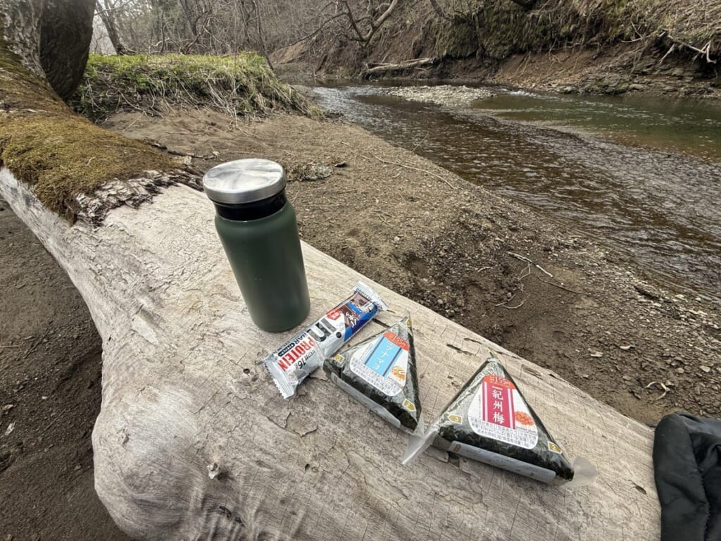 流木をテーブル代わりにした川辺の昼食